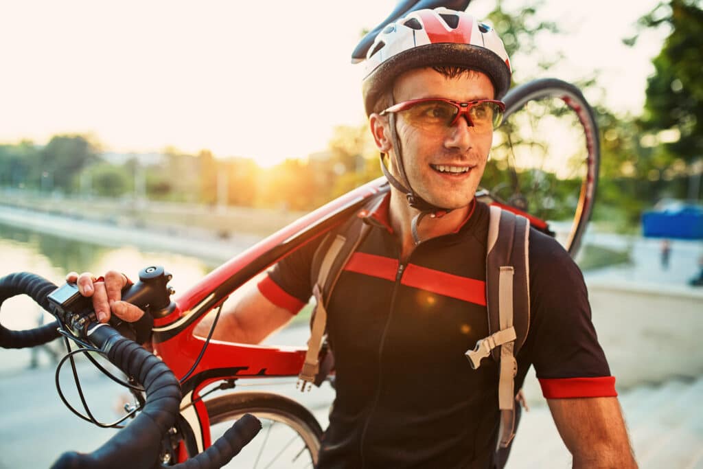 Ciclistas sin experiencia en la carretera sosteniendo una bicicleta en el hombro